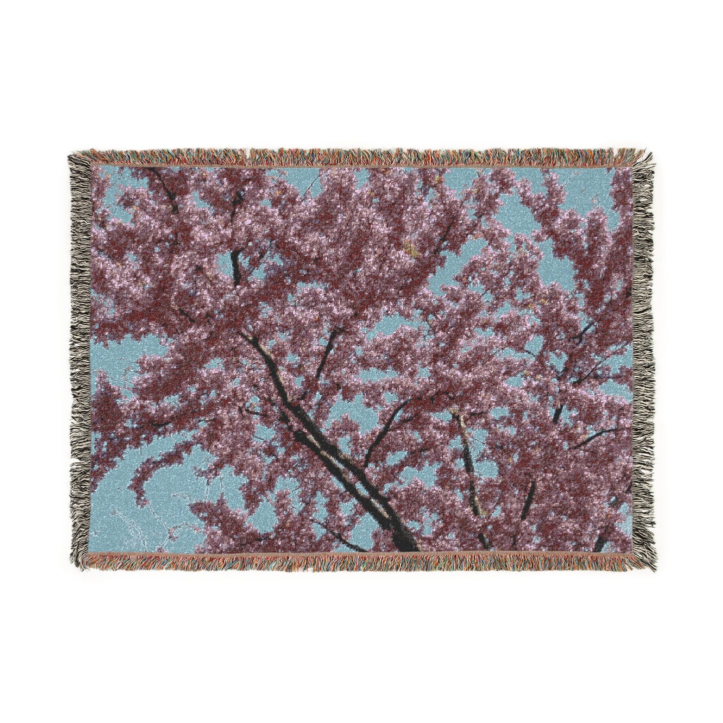Woven blanket with cherry blossom design on a white background