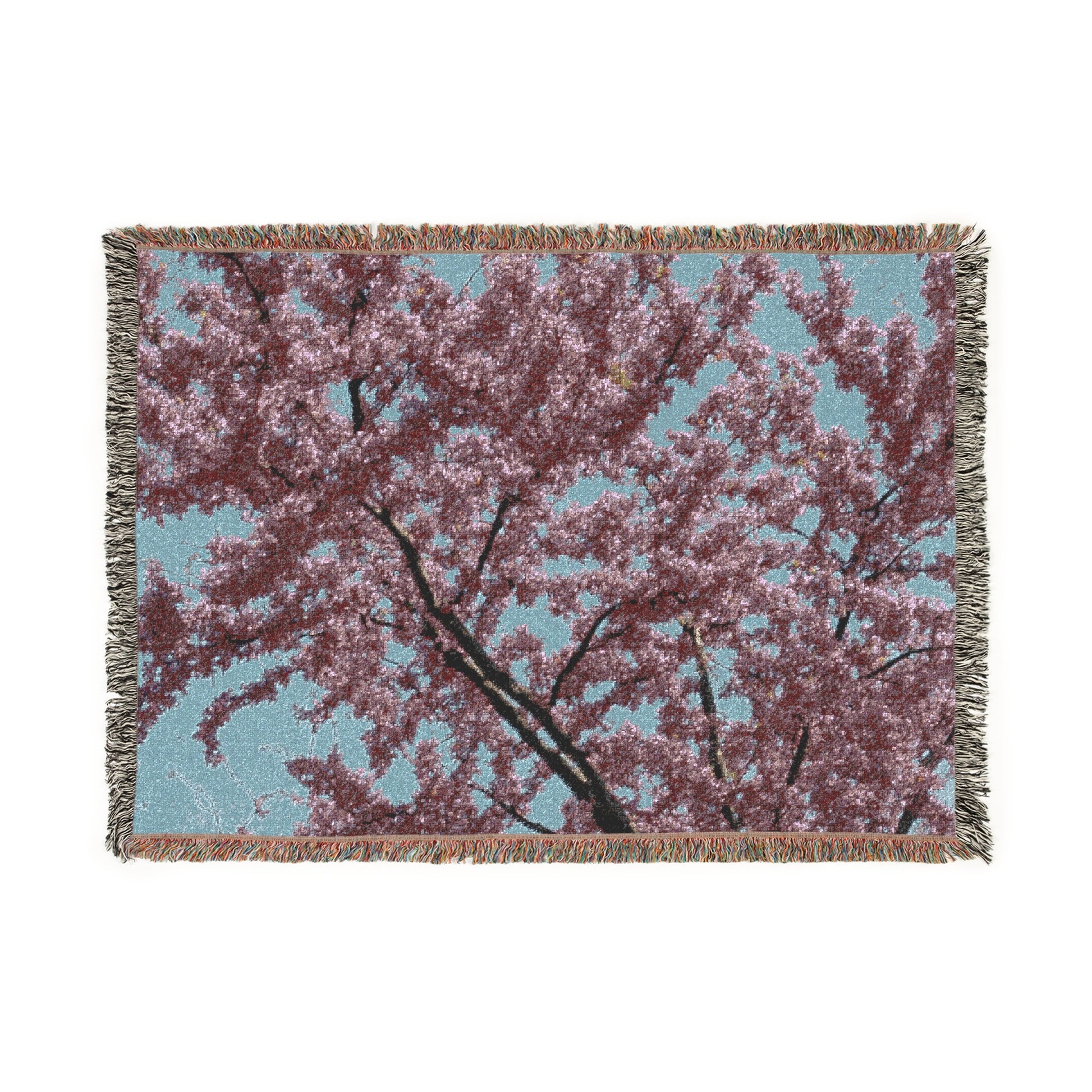 Woven blanket with cherry blossom design on a white background