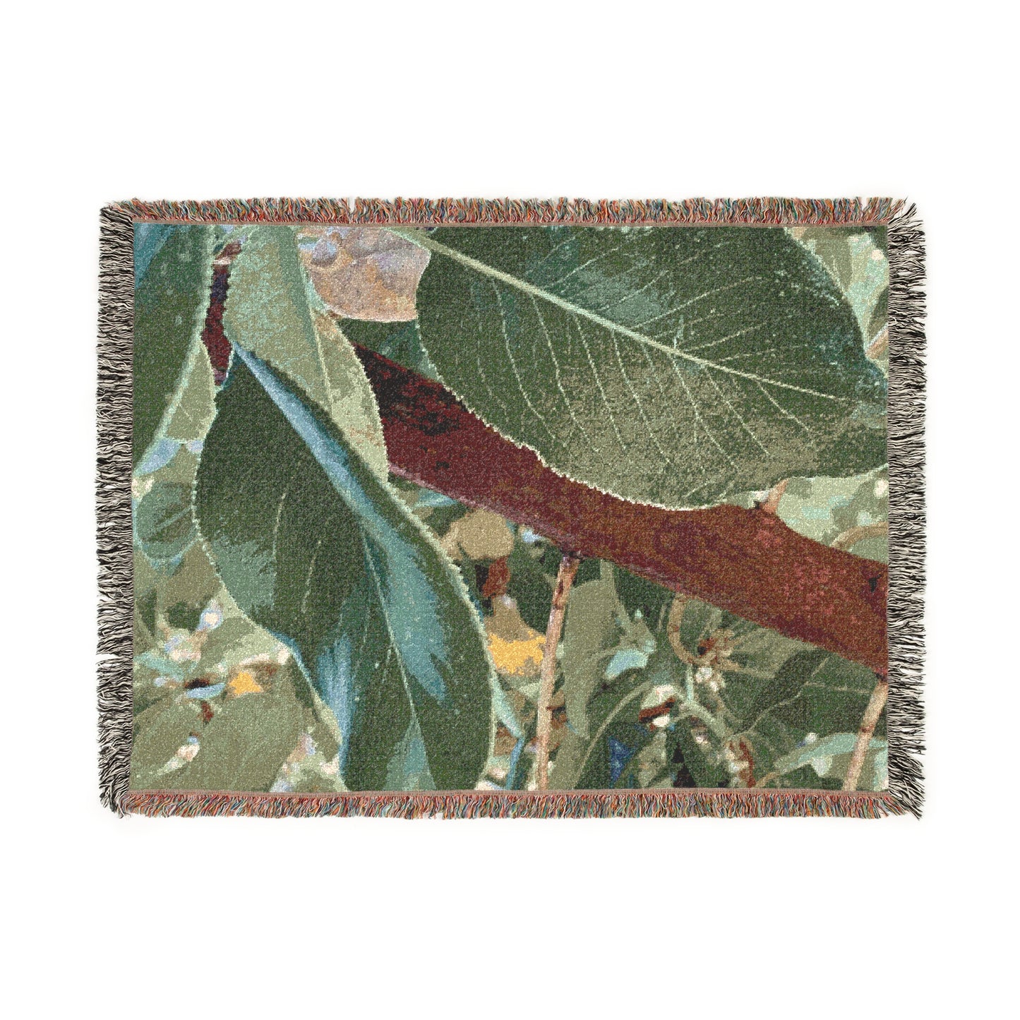 Woven blanket with nature-themed design featuring leaves and branches on a white background